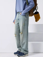 Men’s light-wash wide leg jeans with distressed ripped details on the knees in denim material