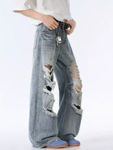 Men’s distressed wide leg jeans in light-wash denim with ripped knees and frayed edges for a casual look