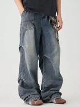 Men’s distressed wide leg denim jeans in faded blue wash with plaid fabric accent tied at the waist