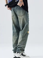 Men’s distressed gray denim jeans with ripped knees and frayed edges in a relaxed fit wide leg style
