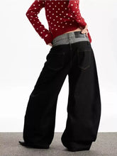 Men’s black wide leg jeans with a contrasting gray waistband paired with a red polka-dot sweater