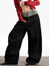 Men’s double waist wide leg jeans in black denim with contrasting gray waistband paired with red polka-dot cardigan