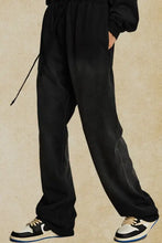 Mens drawstring baggy pants in black with white and black sneakers