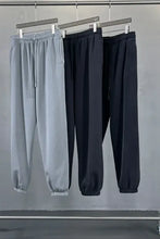 Three pairs of mens drawstring joggers in grey, black, purple with elastic cuffs