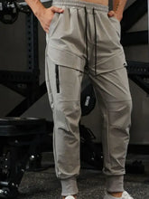 Mens drawstring joggers in light grey with cargo pockets and zippers