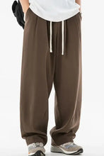 Mens drawstring sweatpants: dark brown wide-leg pants, white t-shirt, sneakers