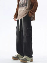 Men’s black distressed denim cargo pants with large side pockets and white drawstrings in a wash wide leg style