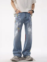 Men’s light-wash denim jeans with artistic splatter print in a loose plus size fit for casual wear