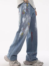 Men’s full size light-wash denim jeans with vibrant artistic splatter print in red yellow blue and white
