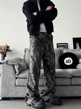 Men’s full size camo print relaxed fit jeans with black and silver wide-leg pants and a glossy reflective finish