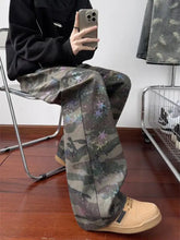 Men’s full size camouflage wide leg jeans with galaxy-inspired stars and nebulae in muted greens grays and purples