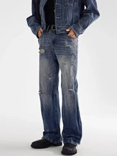 Men’s full size distressed loose fit plus size denim jeans in faded blue with intentional rips and a casual style