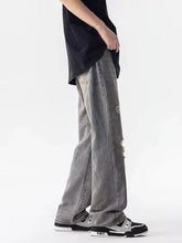 Men’s grey distressed loose fit denim jeans with relaxed wide-leg cut and subtle fading in full size plus size