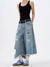 Men’s light-wash denim wide leg jeans with distressed patches and raw hem frayed edges in plus size fit