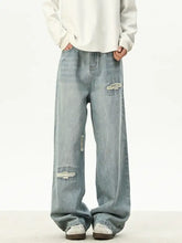 Men’s full size distressed wash loose fit jeans in light-wash denim with ripped details on thighs and knees