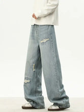 Men’s full size distressed wash light-wash denim loose fit jeans with ripped patches and relaxed wide-leg cut