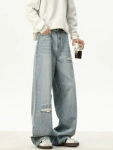Men’s full size distressed wash light-wash denim loose fit jeans with ripped thighs and a relaxed wide-leg cut