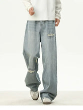 Men’s full size distressed wash loose fit light-wash denim jeans with frayed patches on knees and thigh