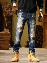 Men’s full size slim fit distressed wash blue denim jeans with colorful embroidered patches and ripped details