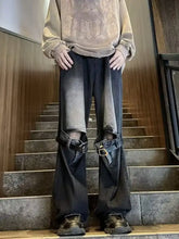 Black denim men’s full size distressed wide leg jeans with ripped knees and reinforced leather leg buckled straps