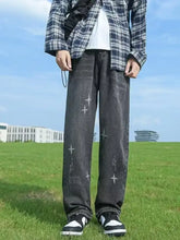 Men’s full size distressed wide leg jeans in dark gray denim with faded wash and white star embroidery along the legs