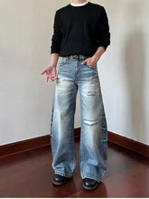 Men’s full size distressed wide leg jeans in faded blue denim with intentional knee distressing and wide leg fit