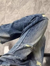 Men’s full size distressed wide leg jeans in blue denim with frayed ripped knees and faded wash offer distressed details