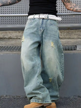 Men’s light-wash distressed wide leg jeans with full size fit paired with a white studded belt