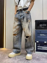Men’s full size distressed wide leg jeans in faded blue denim with intentional rips at the knees for casual wear