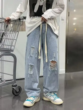 Men’s light-wash denim full size distressed wide leg jeans with ripped details and drawstring waistband