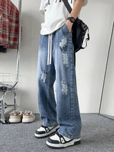 Men’s full size distressed wide leg jeans in blue denim with relaxed fit and white drawstrings featuring wide leg design