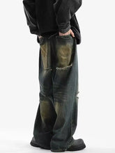Men’s full size distressed wide leg jeans in black and olive green denim with frayed back pockets shown from the back