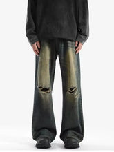 Men’s full size distressed wide leg jeans in dark-wash denim with ripped knees and faded greenish-yellow patches