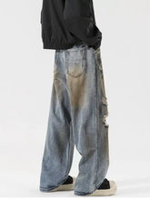 Men’s full size distressed wide leg denim jeans in faded blue with intentional rips along the side seam