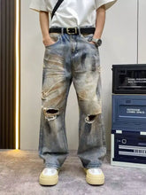 Men’s full size distressed wide leg jeans in faded blue and brown wash with ripped knees and frayed edges