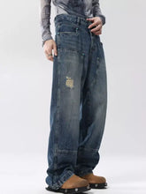 Men’s full size distressed wide leg jeans in faded blue denim with distressed patchwork and reinforced stitching slightly stretchy