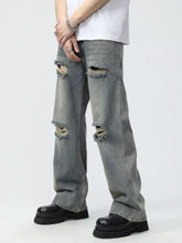 Mens full size distressed gray denim wide leg jeans with multiple ripped knee holes and frayed edges plus size