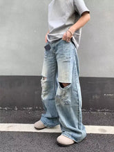 Men’s full size distressed wide-leg jeans in light-wash denim with ripped details on thighs and knees