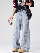 Men’s plus size wide-leg jeans in light-wash denim with distressed wash and paint-splatter effects