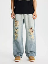 Men’s full size distressed wide leg jeans in light wash denim with ripped knees and frayed edges front view