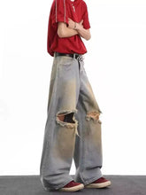 Men’s full size distressed wide leg light-wash denim jeans with ripped knees and a faded worn-in look