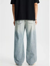 Men’s full size distressed wide leg jeans in light-wash denim with a relaxed fit and faded gradient effect from waist to hem