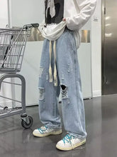 Men’s full size distressed wide leg jeans in light wash denim with ripped details and drawstring waistband