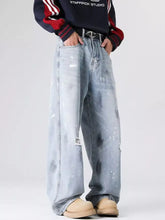 Men’s plus size wide-leg jeans in light distressed wash with paint splatter design and full size fit