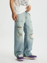 Men’s full size distressed wide leg jeans in light-wash denim featuring multiple rips and frayed edges