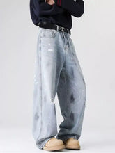 Men’s plus size light-wash denim wide-leg jeans with distressed wash patches and paint-splatter accents