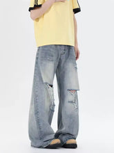Men’s light-wash denim plus size distressed wide leg jeans with intentional rips and frayed edges for casual wear