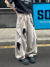 Men’s light-wash distressed wide leg jeans with black-frayed patches and chain accessory plus size leg jeans