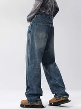 Men’s full size distressed wide leg jeans in washed blue denim with slightly stretchy fabric and frayed cuffs care instructions included