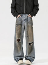 Men’s full size distressed wide leg denim jeans in faded blue wash with intentional knee rips